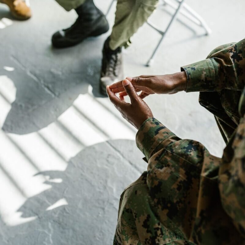 Soldiers engage in group therapy, fostering support and mental health in an indoor setting.
